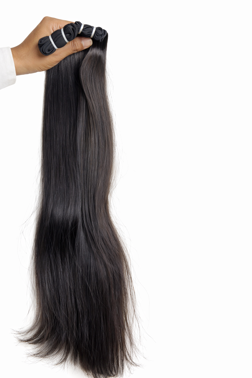 raw virgin indian hair extensions held by a hand on a white background